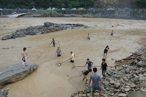 暴雨导致雷山洪水 灾民淡定洪水中捞鱼